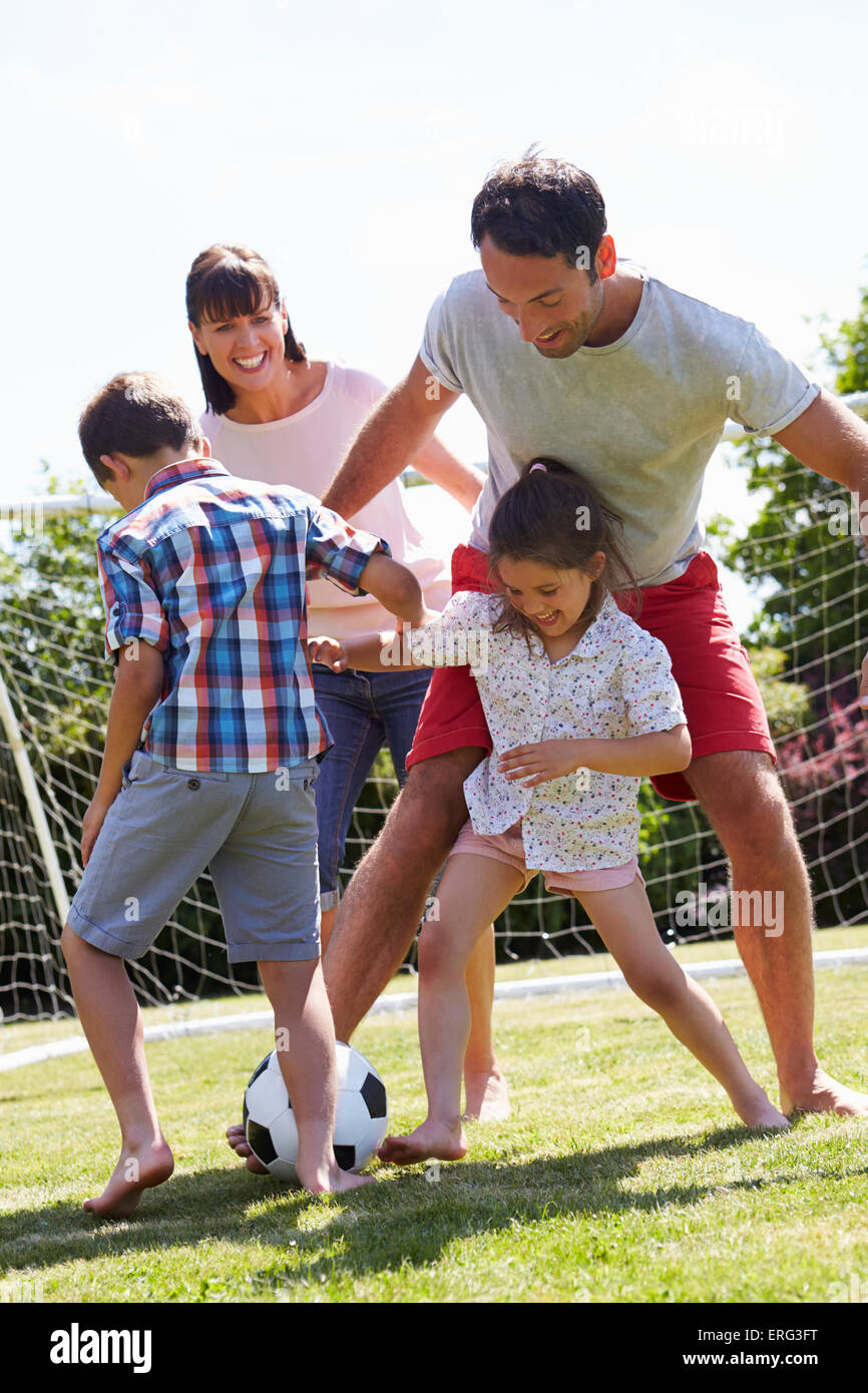 Family Playing Football In Garden Together Stock Photo - Alamy