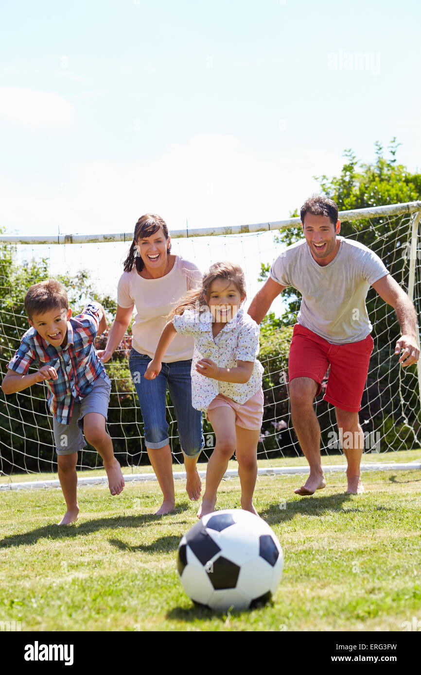 Family Playing Football In Garden Together Stock Photo - Alamy