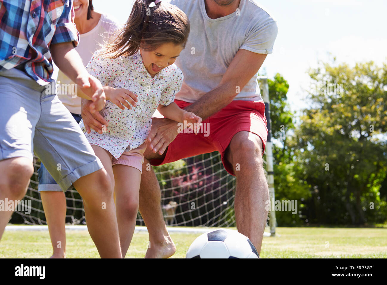 Family Playing Football In Garden Together Stock Photo - Alamy