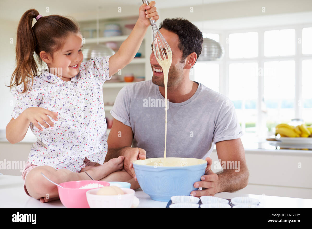 Father And Daughter Baking Cake In Kitchen Stock Photo