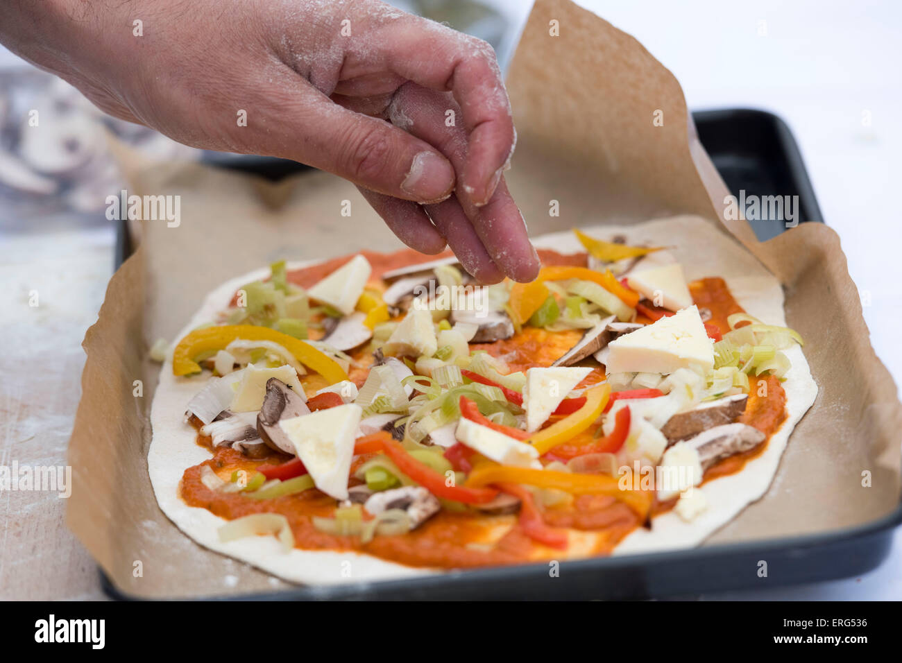 Vegetarian pizza being made in a baking tray. Stock Photo