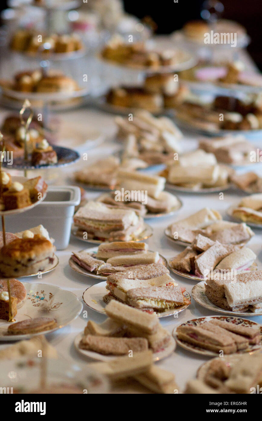 A table of sandwiches and cakes during afternoon tea. Stock Photo