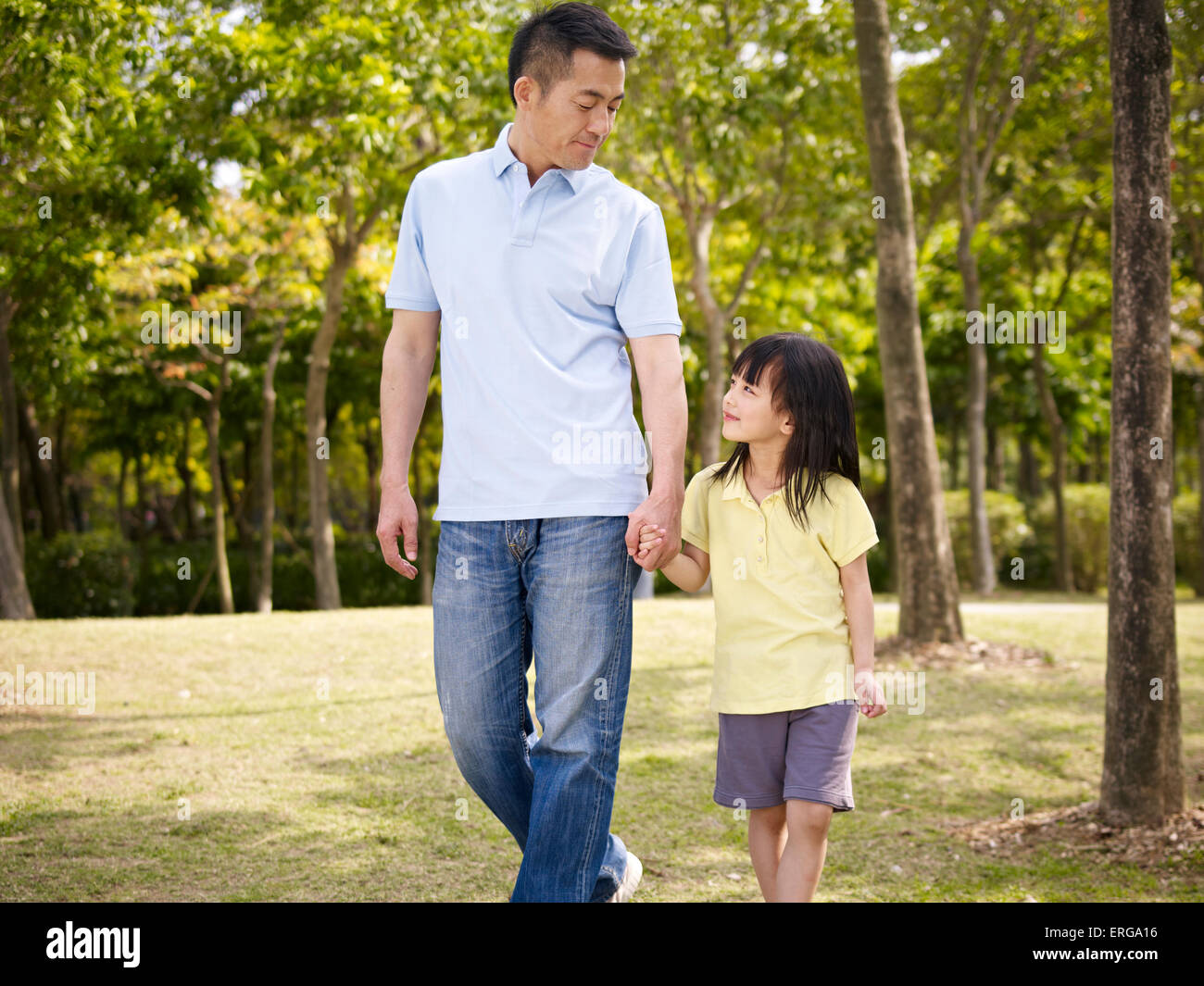 asian father and daughter taking a walk in park Stock Photo
