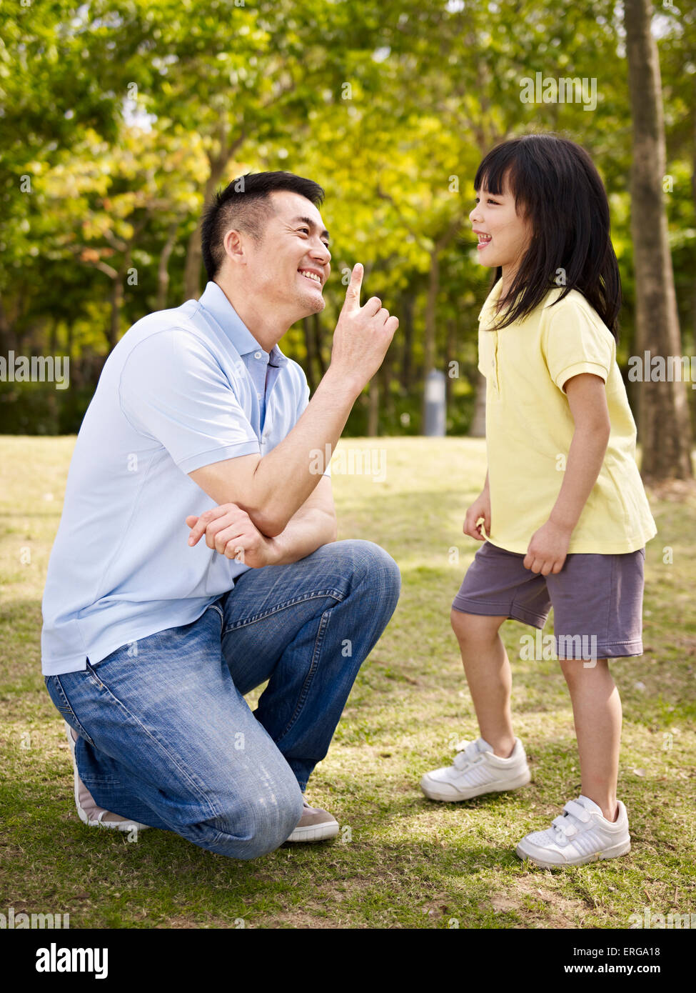 asian father and daughter having a conversation outdoors. Stock Photo