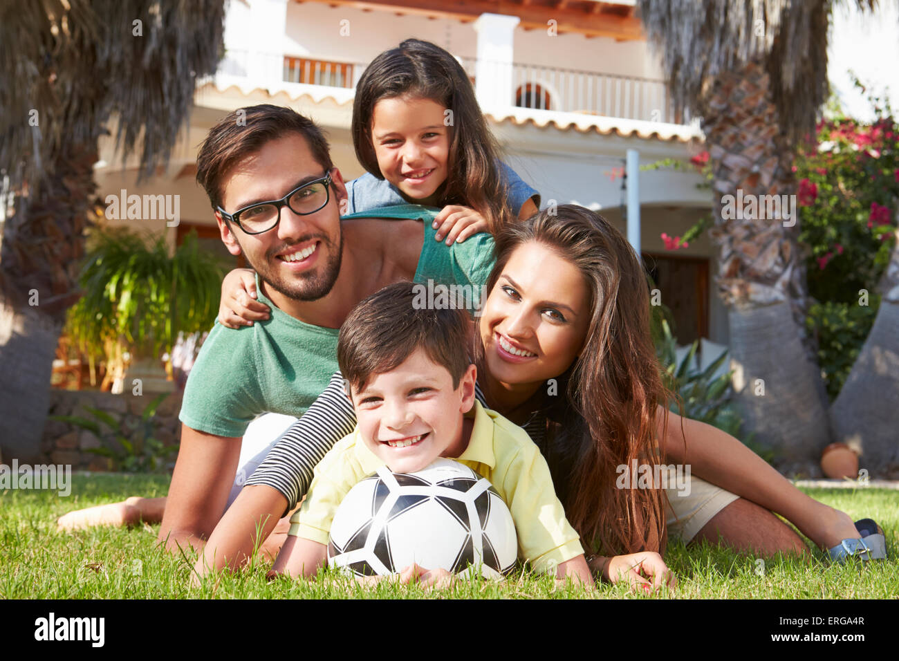 Family Lying In Pile Up On Grass Together Stock Photo - Alamy