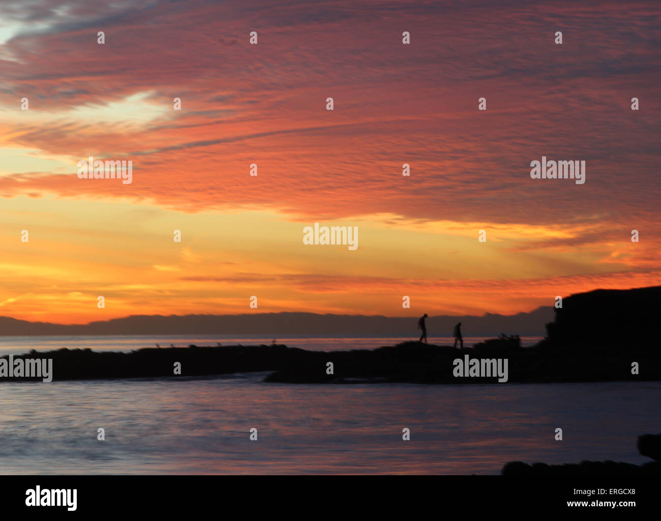 Sunset over the ocean and rock jetty at Shaw’s Cove in Laguna Beach, Southern California Stock Photo