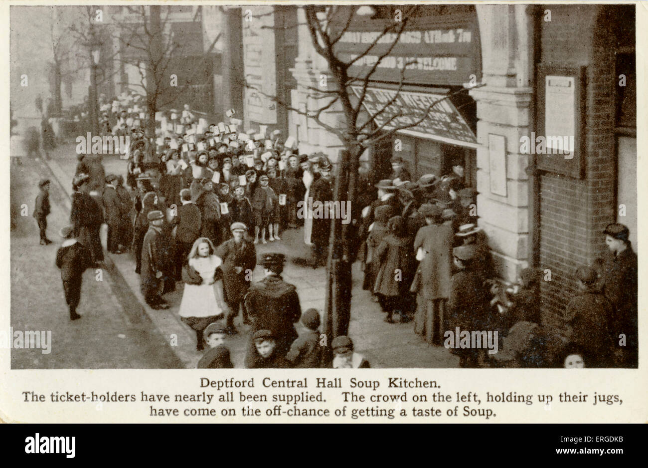 Deptford Central Hall Soup Kitchen, 1900s. The Deptford Central Hall was built by the Methodist Church on slum clearance land in 1903 and set up soup kitchens and other initiatives to help the poor in the area. Caption reads: 'The ticket-holders have nearly all been supplied. The crowd on the left, holding up their jugs, have come on the off-chance of getting a taste of Soup'. Stock Photo