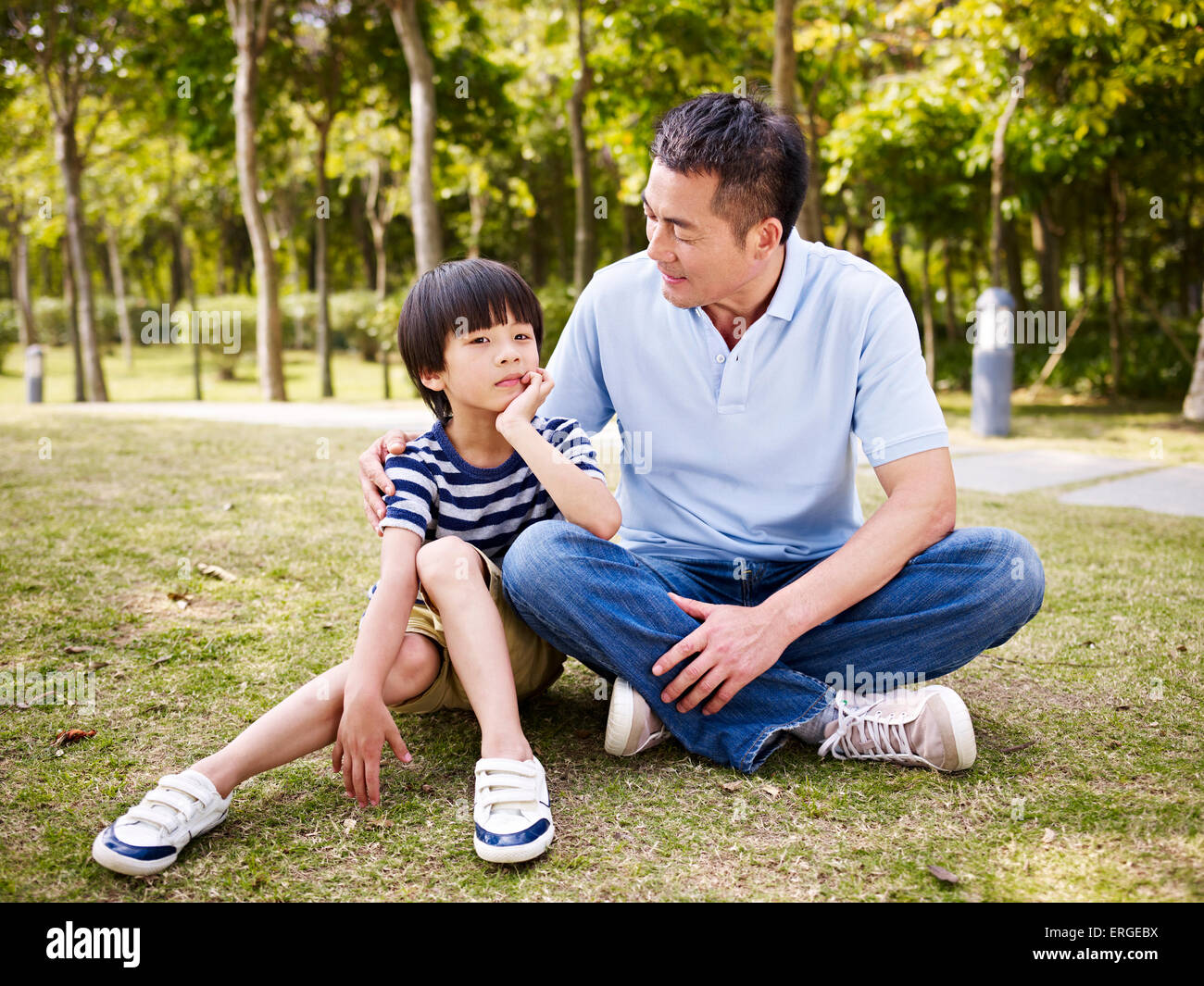 asian father and son talking outdoors Stock Photo