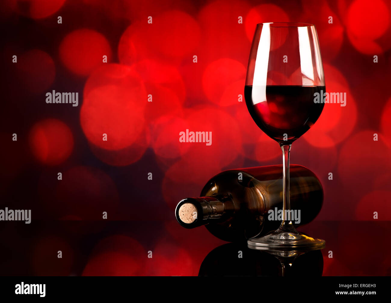 Red wine in wineglass and bottle on red background Stock Photo