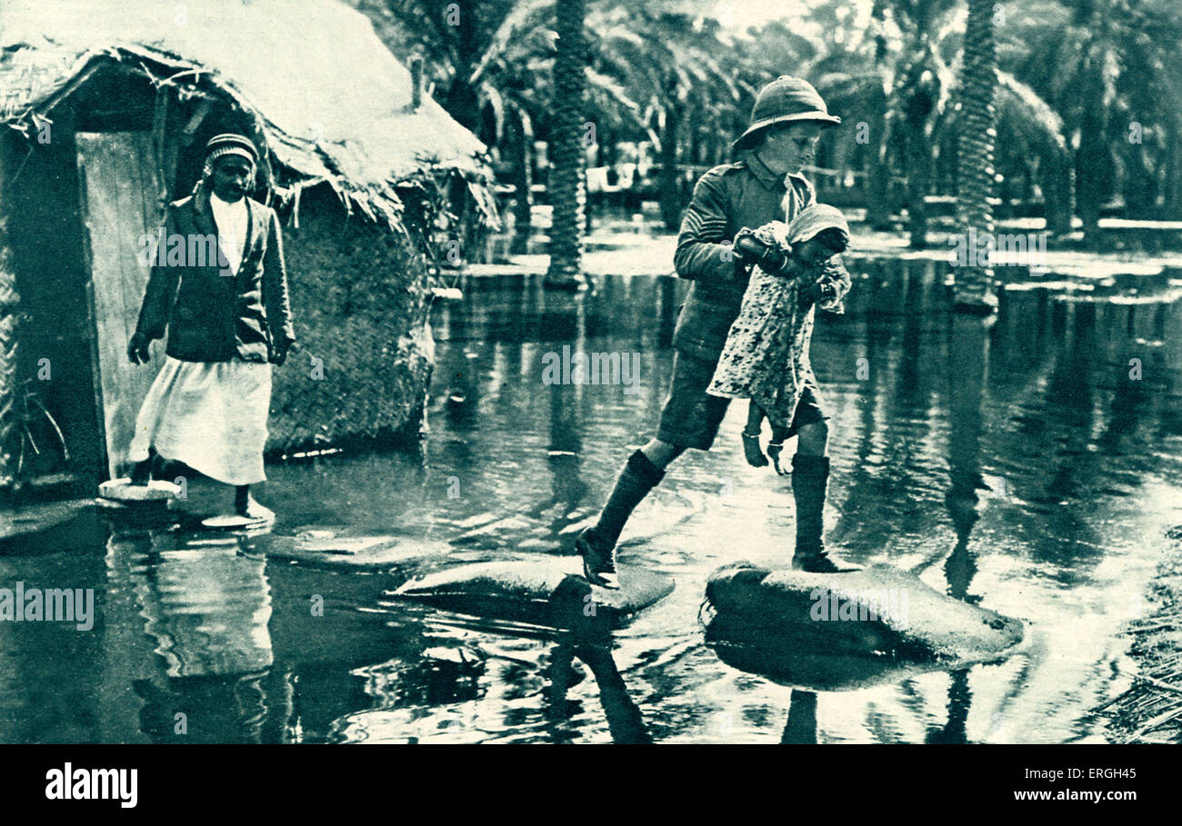 British Army in Mesopotamia during World War 1: soldier carrying a girl across flood water, 1916. Modern day Iraq. Stock Photo