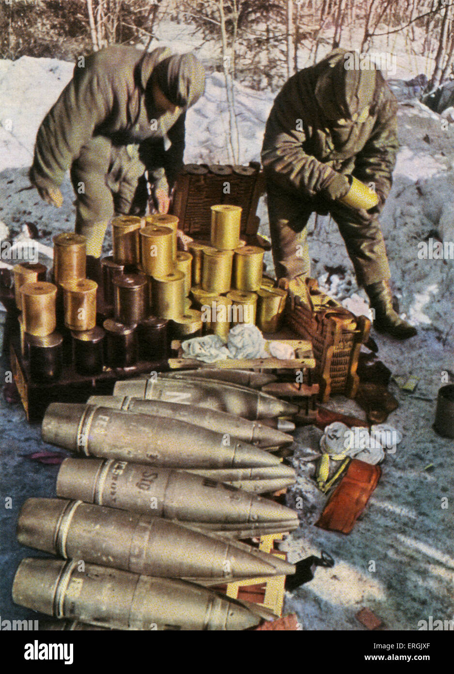 German soldiers handing artillery ammunition during a winter battle, WW2. Caption: 'Use of munition is just as big during winter battles'/ 'El consumo de municion es tambien grande en las batallas invernales'. Spanish postcard intended for supporters of Franco' s Republic which was in favour of the Third Reich. Stock Photo