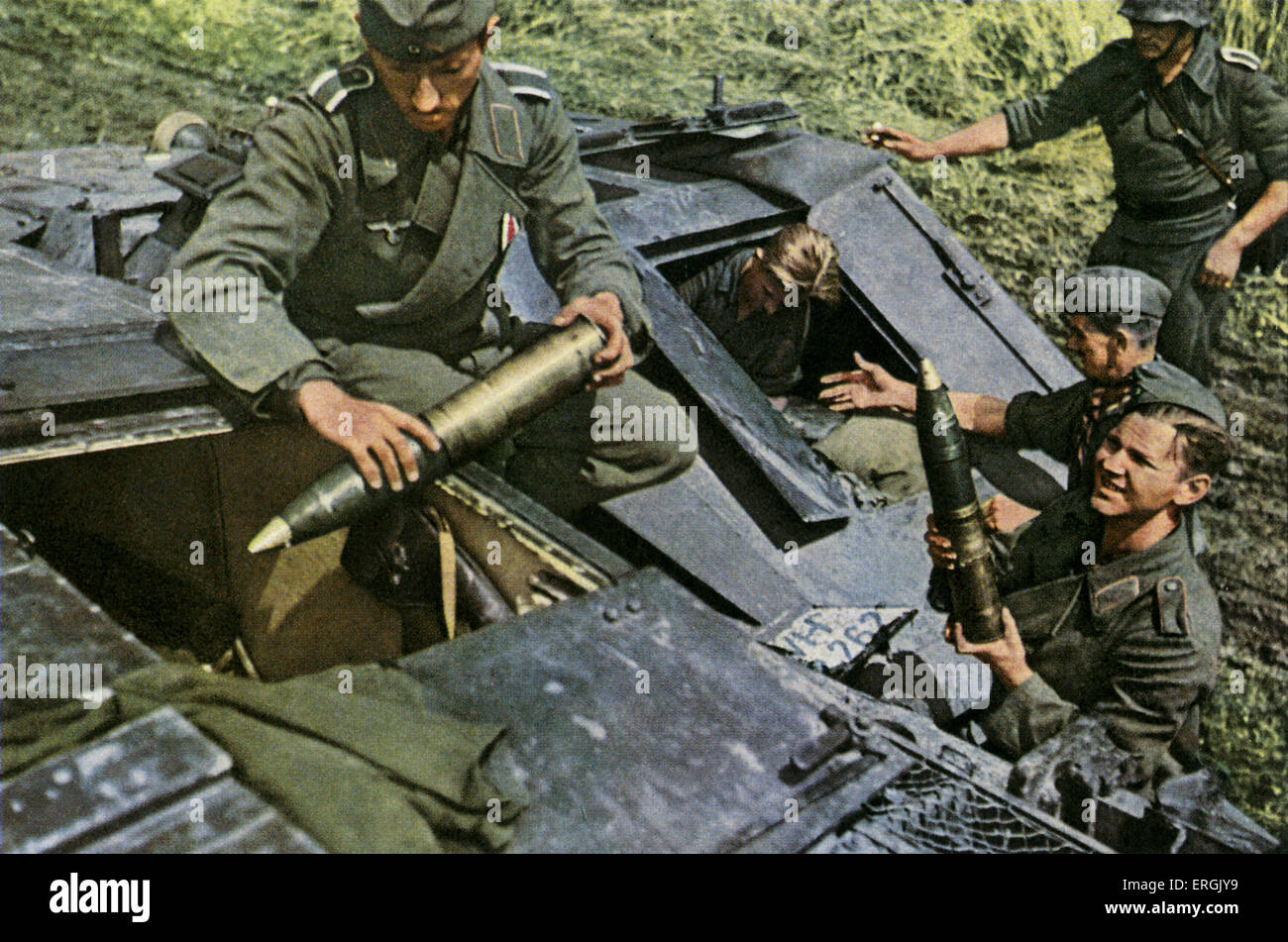 German soliders loading muitions into an assault gun, World War 2. Also know as a howitzer. Spanish postcard intended for Stock Photo