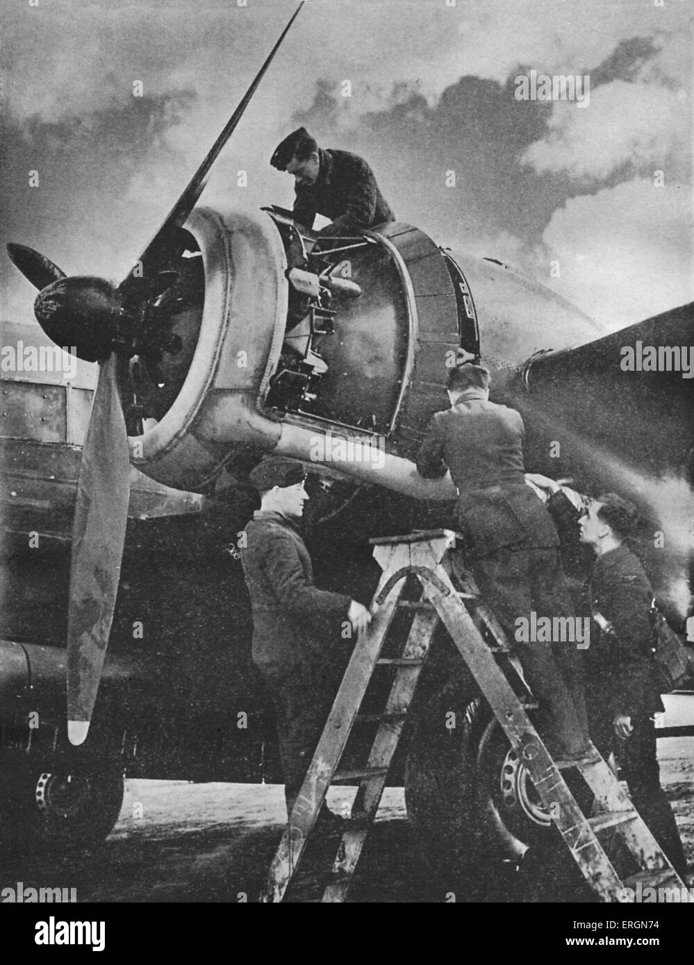 WW2 - Ground crew tuning the engine of a British bomber. Caption reads: Before the raid. The ground crew tuning the engine of a Stock Photo
