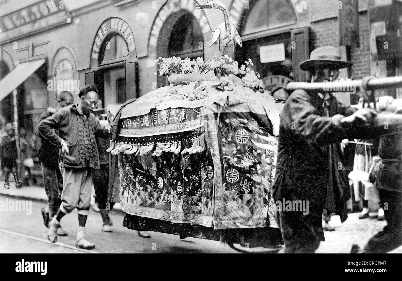 Funeral procession for a wealthy person, coffin draped in decorative fabric and ornamented with flowers and bird sculpture. Stock Photo