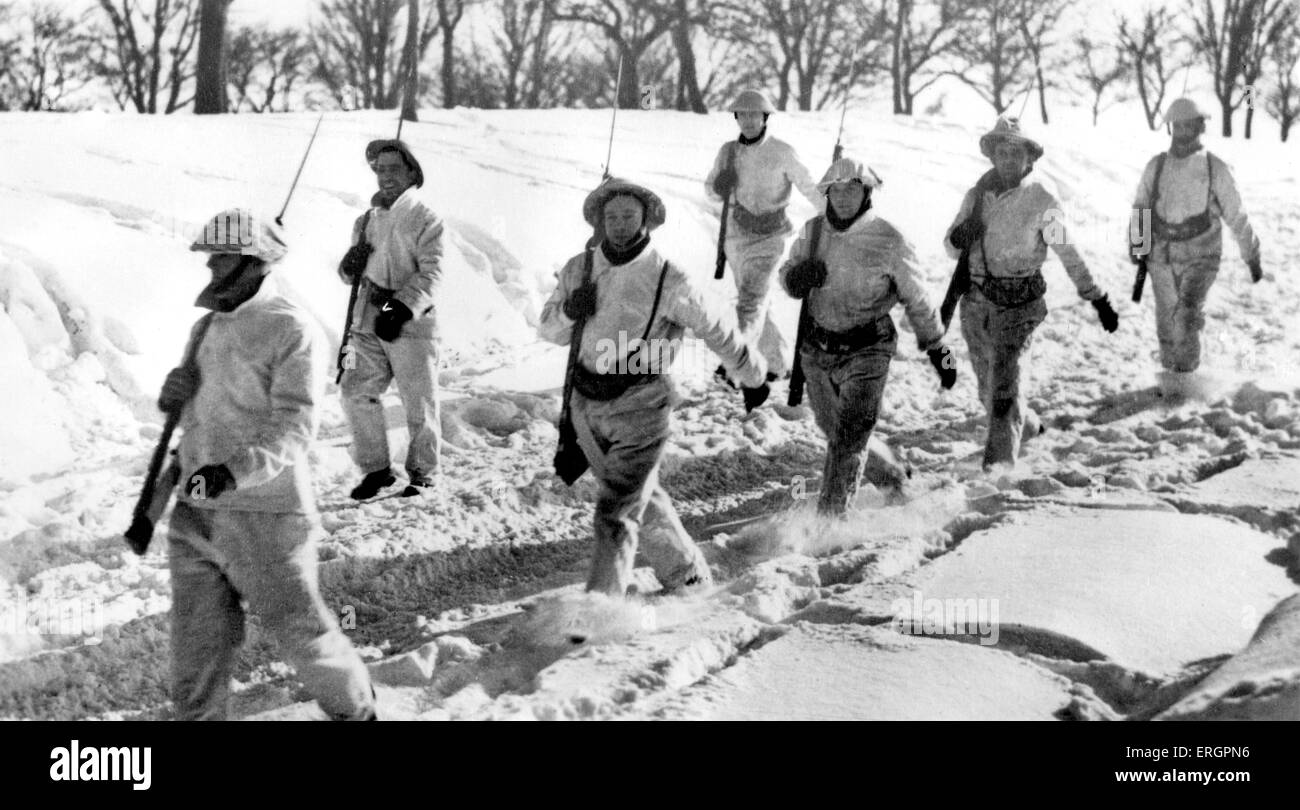 WWII - Winter on the Western Front, soldiers with bayonets march through the snow. Caption reads:  'Wearing white camouflage, Stock Photo
