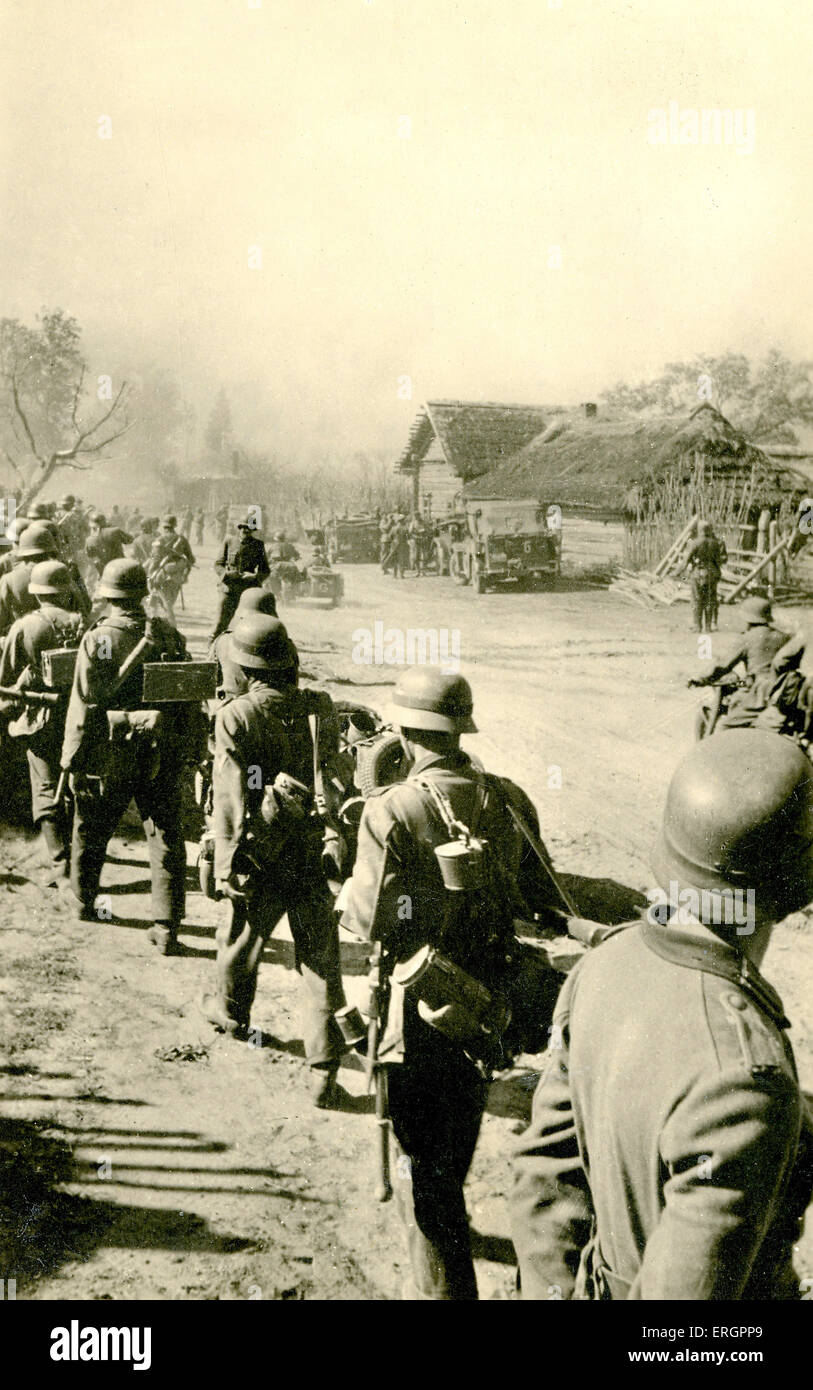 WW2 -  Eastern Front. Line of German soldiers marching through country village, Soviet Union. Caption reads: ' Soviet Union, Stock Photo