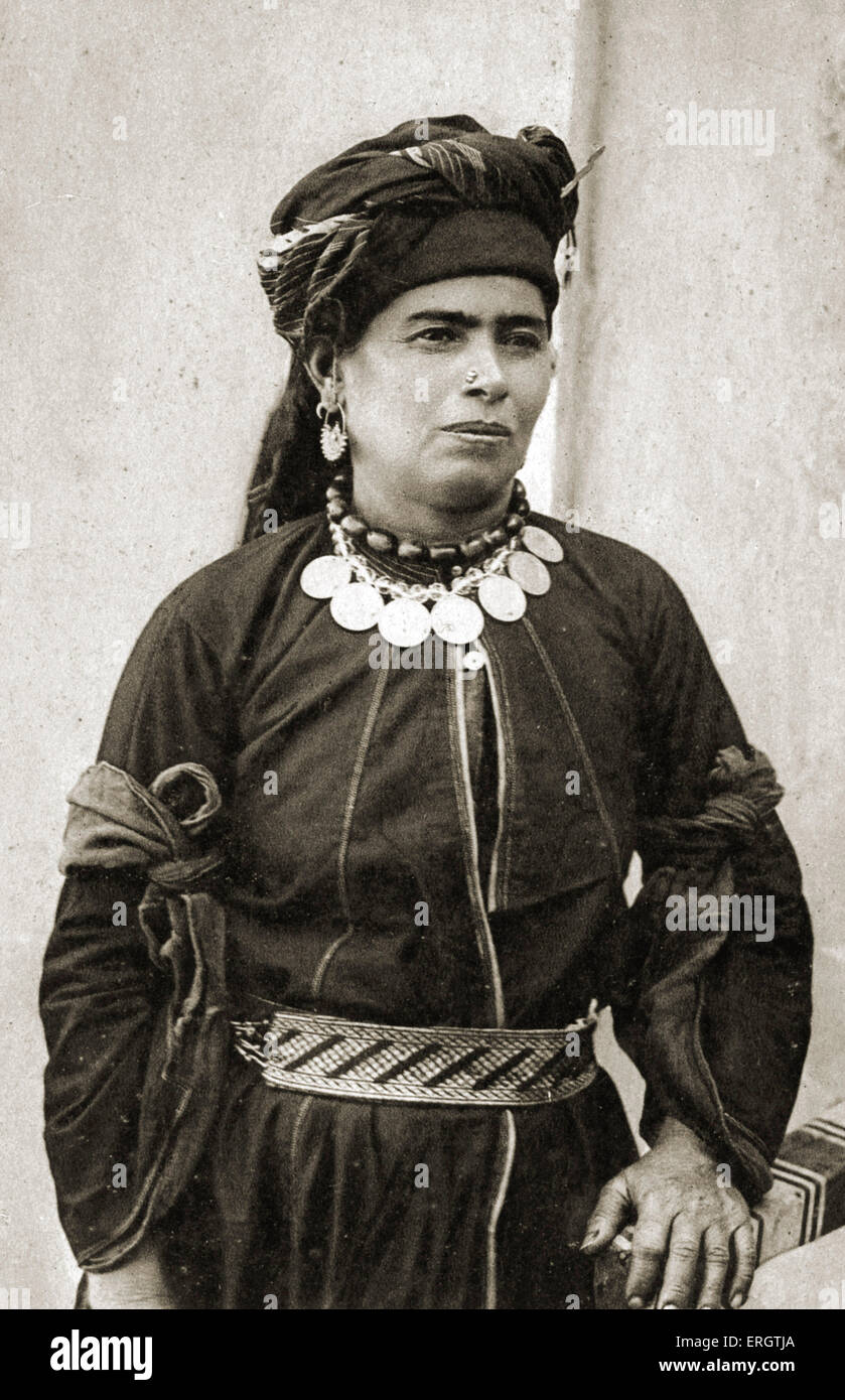 Iraq - Kurdish woman in her best costume of black Persian silk with silver belt and her necklace of amber beads with Turkish Stock Photo