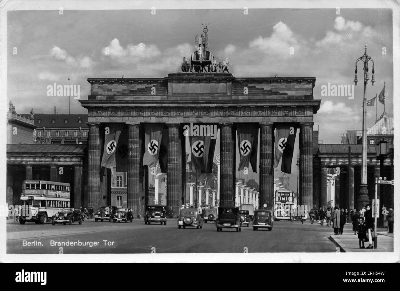 Berlin, Germany:The Brandenburg Gate / Brandenburger Tor. Nazi party flags cover the city gate. Postcard stamped on rear 7 July 1941. The Brandenburg Gate was commissioned by King Frederick William II of Prussia (25 September 1744 – 16 November 1797) and originally built by architect Carl Gotthard Langhans (Prussian architect, 15 December 1732 – 1 October 1808) from 1788 to 1791. Stock Photo