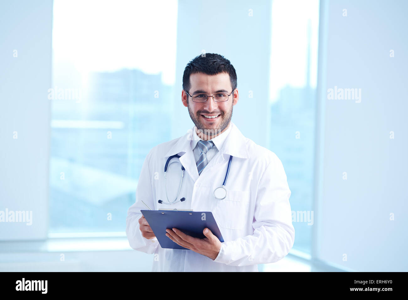 Smiling doctor with clipboard and stethoscope looking at camera Stock ...
