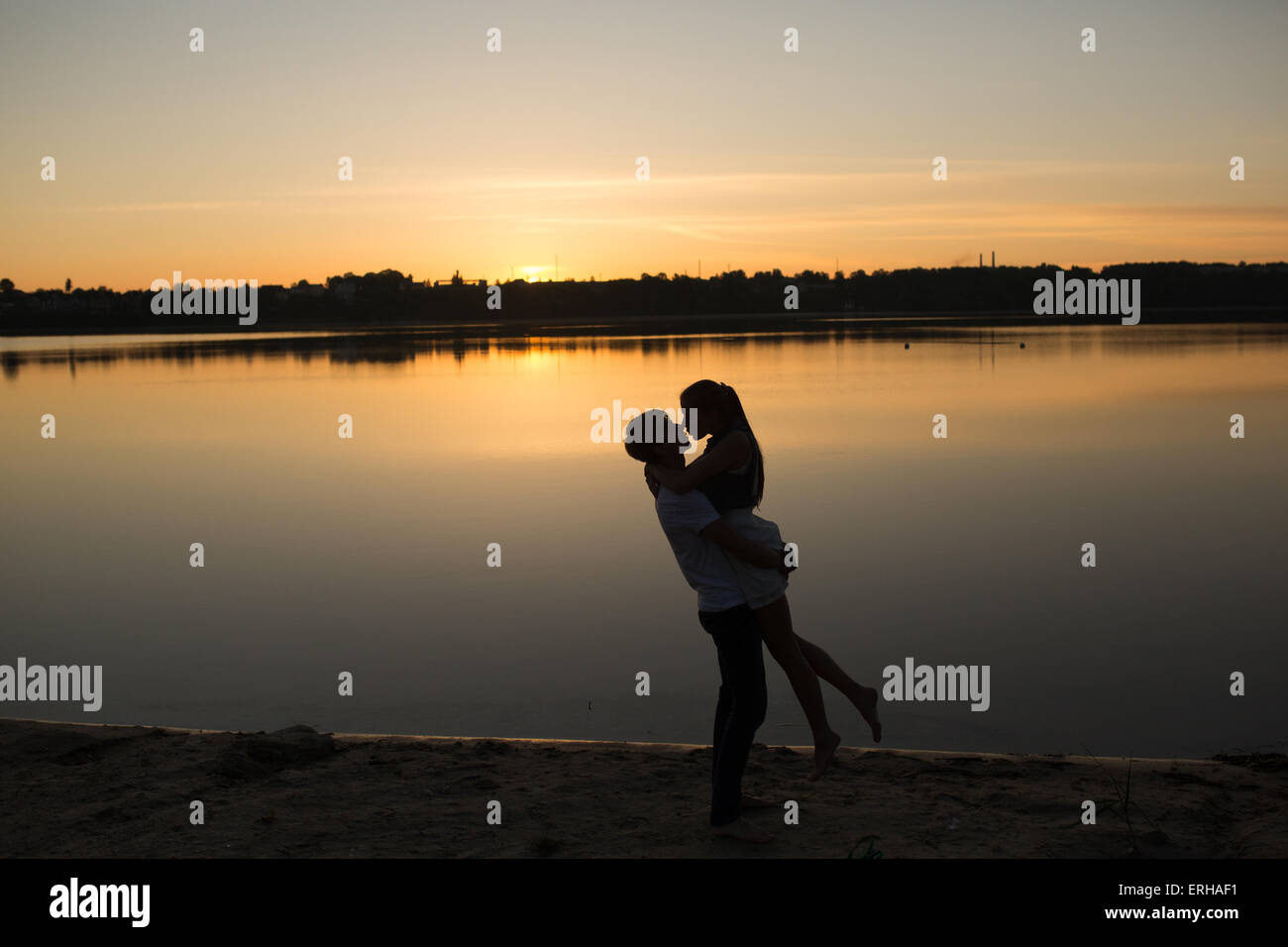 Couple in sunrise on the beach Stock Photo - Alamy