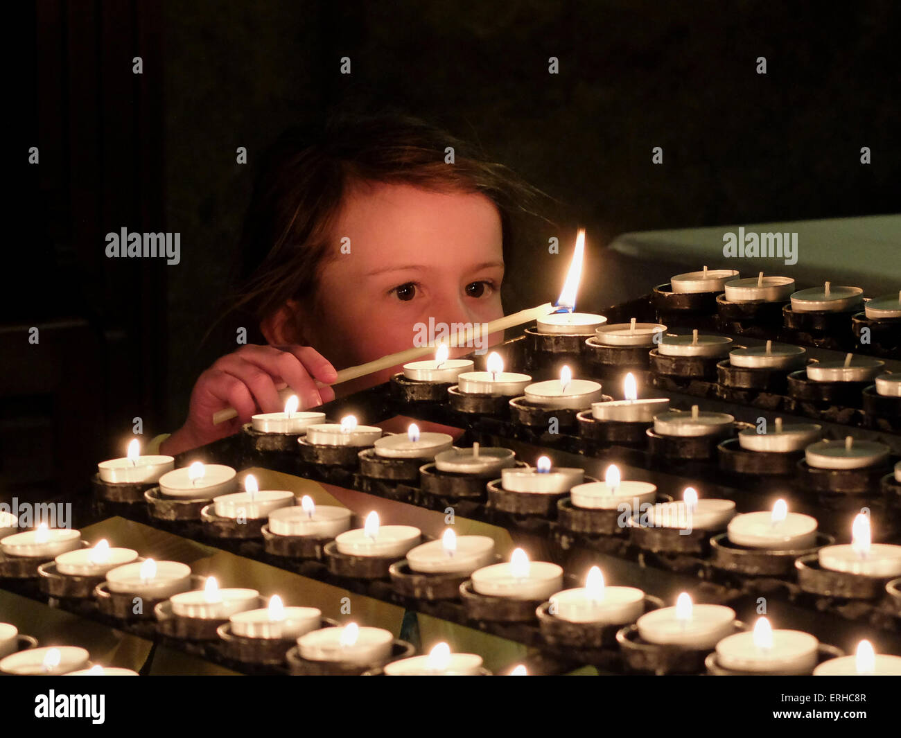 Young girl lighting a candle in church Stock Photo Alamy