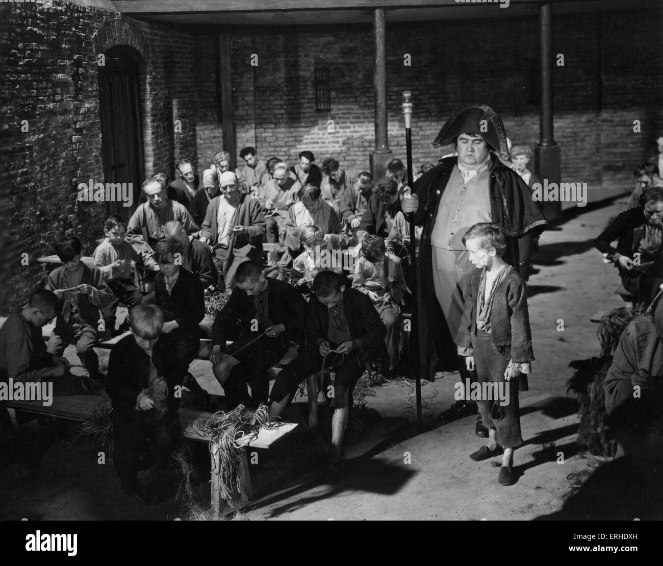 Oliver Twist film still from 1948 Rank Film production of Charles Dickens. British novelist, 7 February 1812 - 9 June 1870. With Robert Newton as Bill Sykes, Alec Guiness as Fagin, Kenneth Downy as Workhouse Master, John Howard Davies as Oliver. Directed by David Lean, Music by ARNOLD BAX. Stock Photo