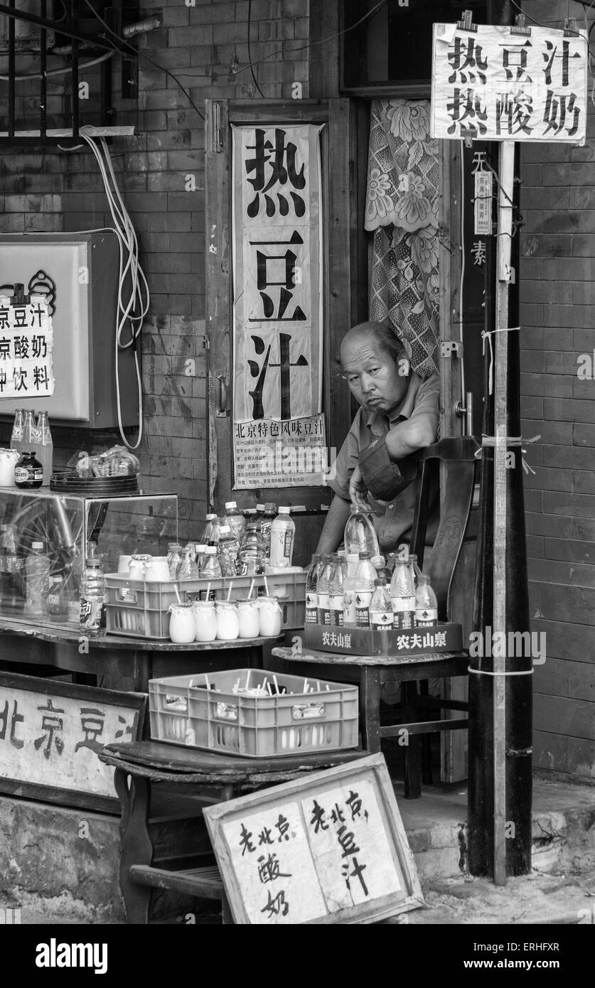 Shopkeeper surrounded by signs with Chinese characters in Beijing, China Stock Photo