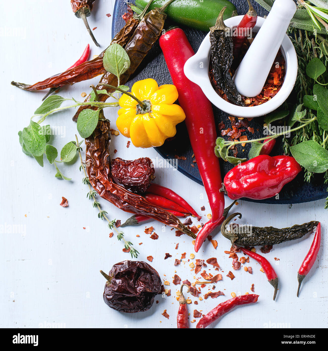Assortment of fresh, dryed and flakes hot chili peppers and fresh herbs ...