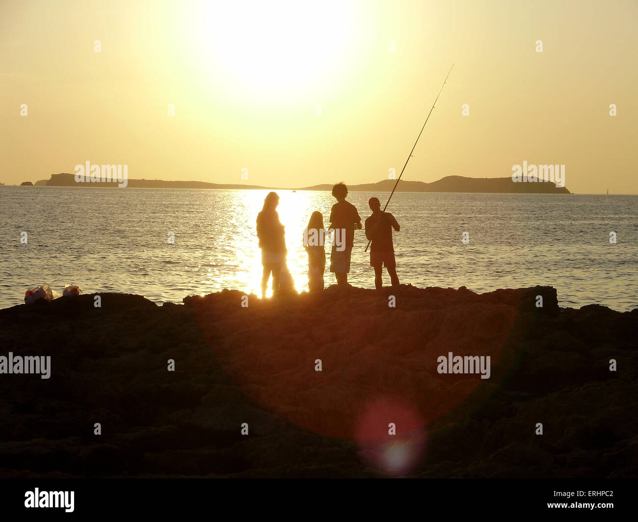 Friends fishing on the rocks in Ibiza Stock Photo - Alamy