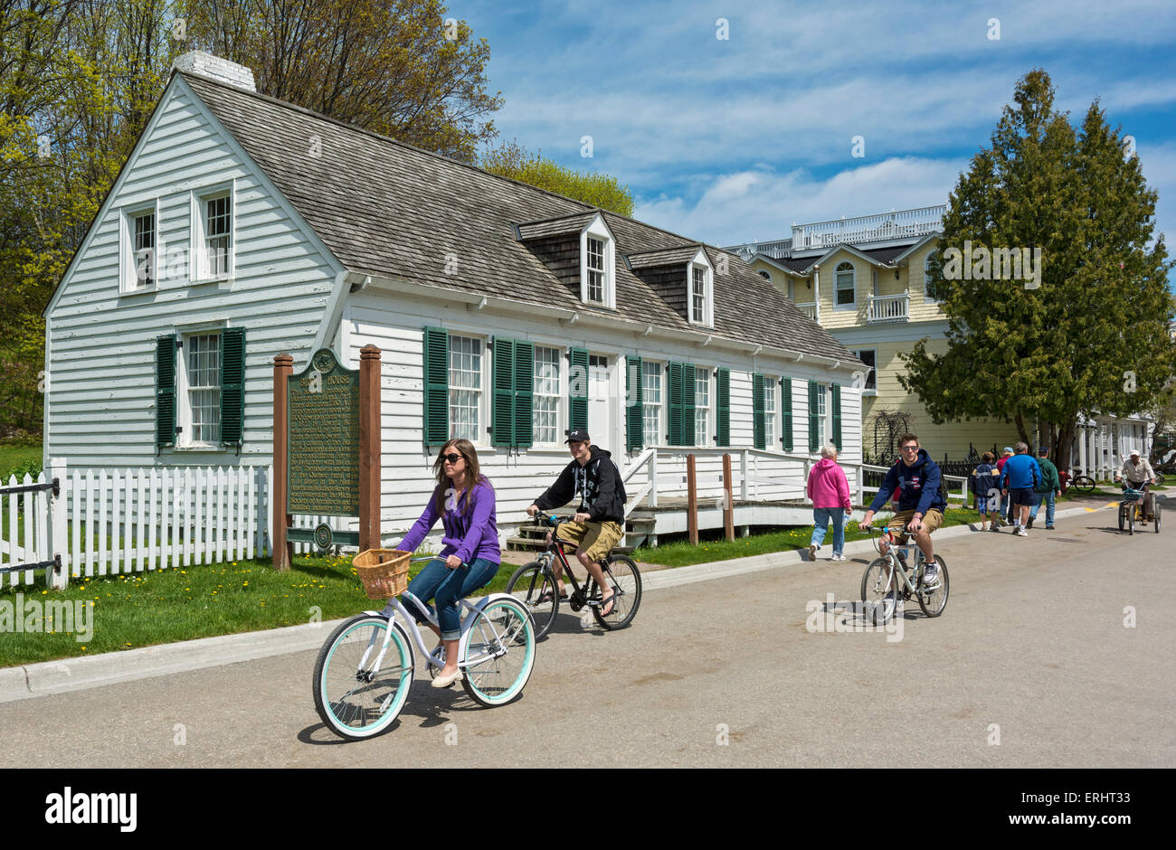 Michigan, Mackinac Island, Market Street, bicyclists pass historic Biddle House Stock Photo