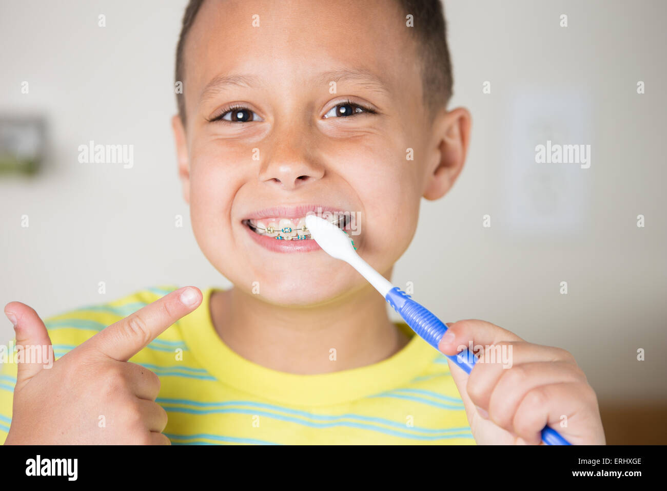 Young boy brushing pointing to his teeth while brushing Stock Photo Alamy