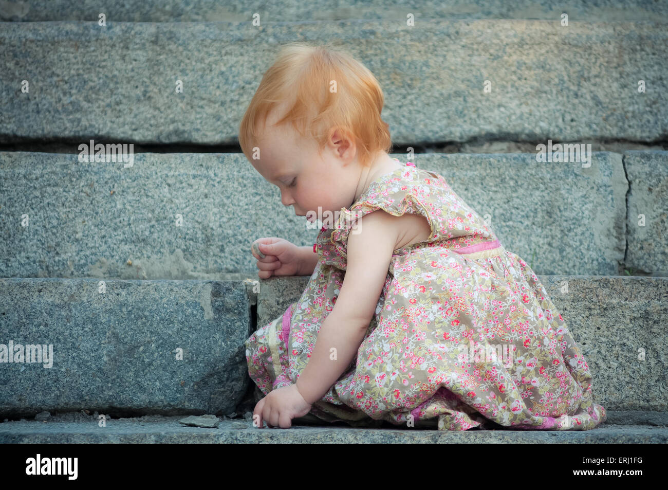 Cute Little baby find something on the ground - outdoors. Color version Stock Photo