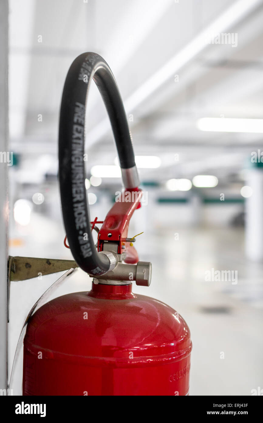 Extreme close-up of a fire extinguisher placed on the column of a car