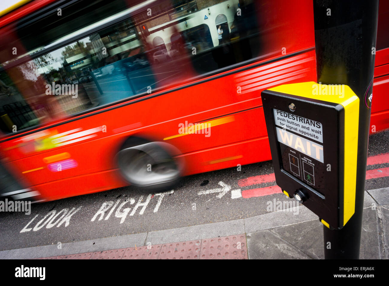 A bus speeds past a pedestrian crossing with a look right sign Stock