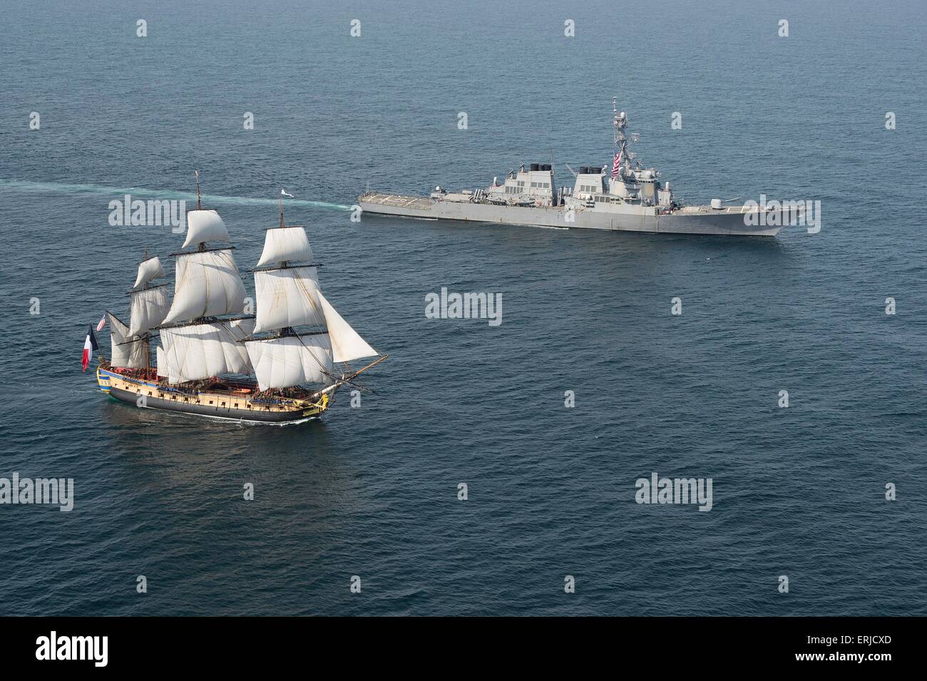 The US Navy Arleigh Burke-class guided-missile destroyer USS Mitscher escorts the French tall ship replica the Hermione in the vicinity of the Battle of Virginia Capes June 2, 2015 in the Chesapeake Bay, Virginia. The original the Hermione brought French Gen. Marquis de Lafayette to America in support of the American Revolutionary War. The symbolic return of the Hermione will pay homage to Lafayette and the Franco-American alliance that brought victory at the Battle of Yorktown in 1781. Stock Photo