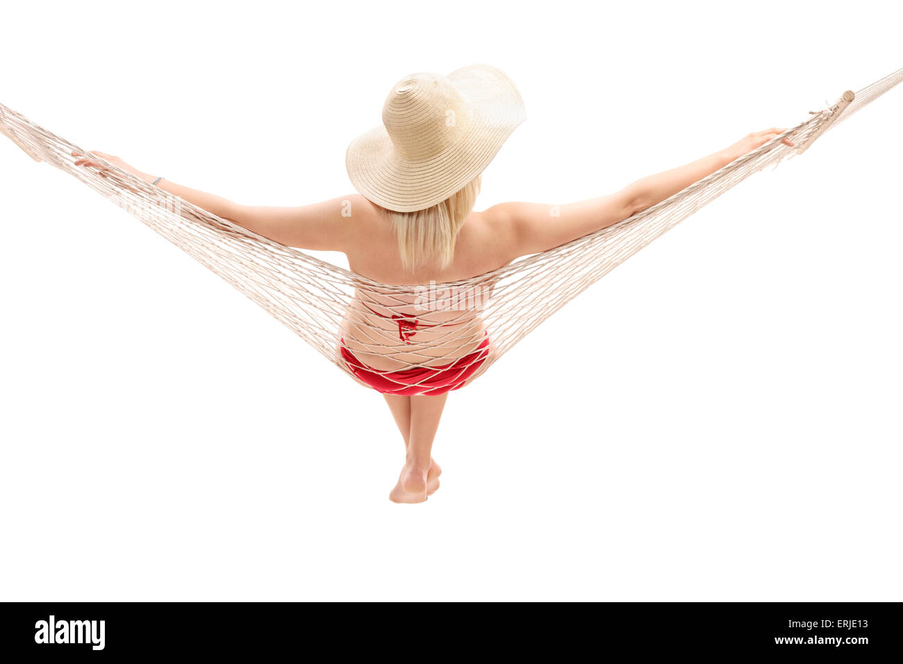 Rear view studio shot of a young woman in a red bikini sitting in a hammock isolated on white background Stock Photo