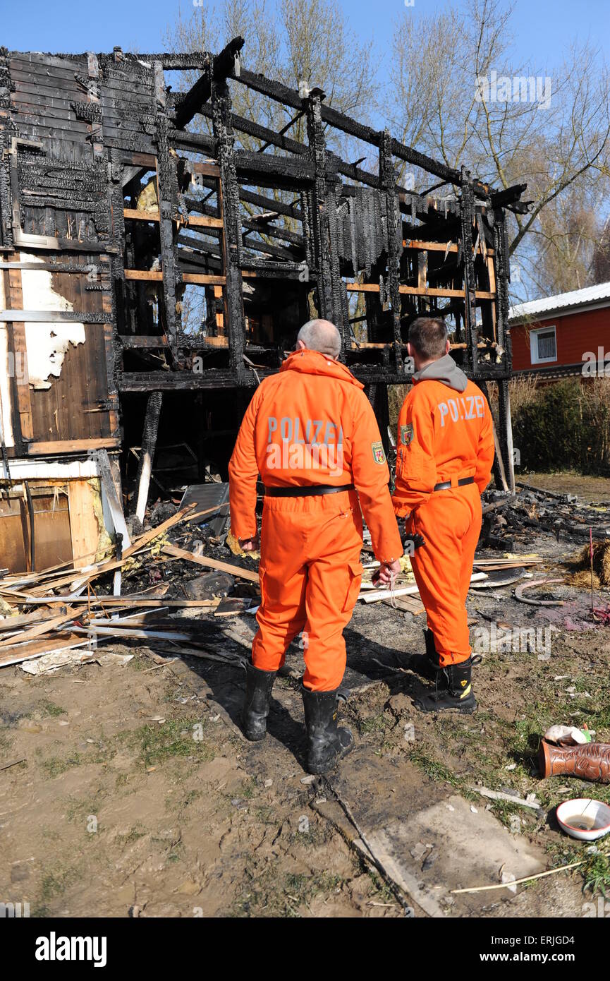 Two Police Men Examine House Destroyed By Fire Stock Photo