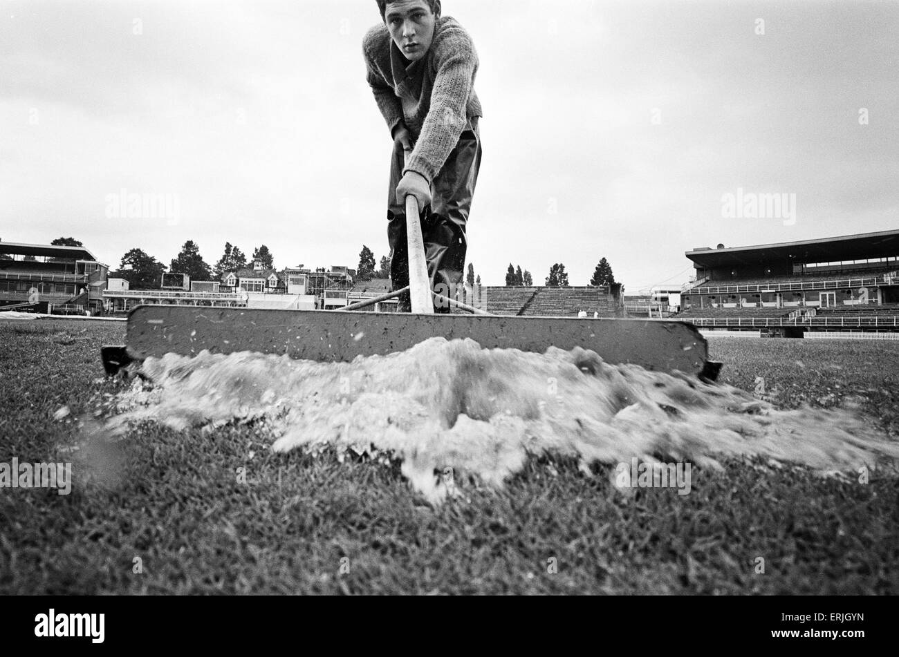 Groundsman Ian Guys tries to clear the water from the pitch at Edgbaston ahead of the third test match between England and Australia for the Ashes. 11th July 1968. Stock Photo