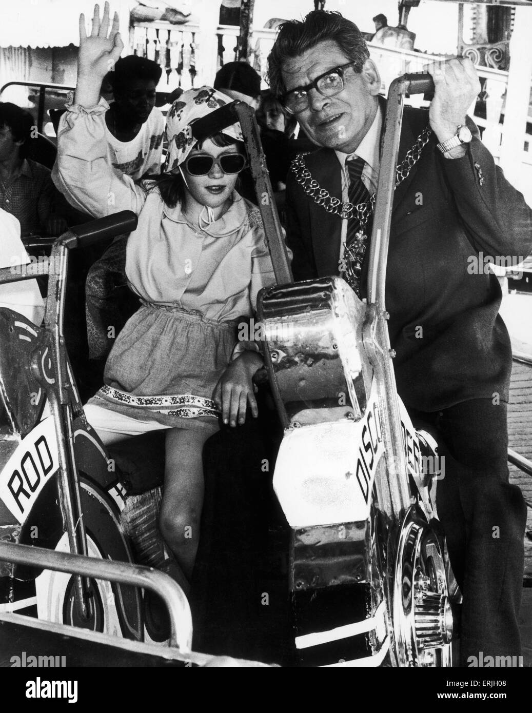 Councillor Weaver with one of the youngsters from Wisteria Lodge on the merry-go-round.  2nd June 1982 Stock Photo