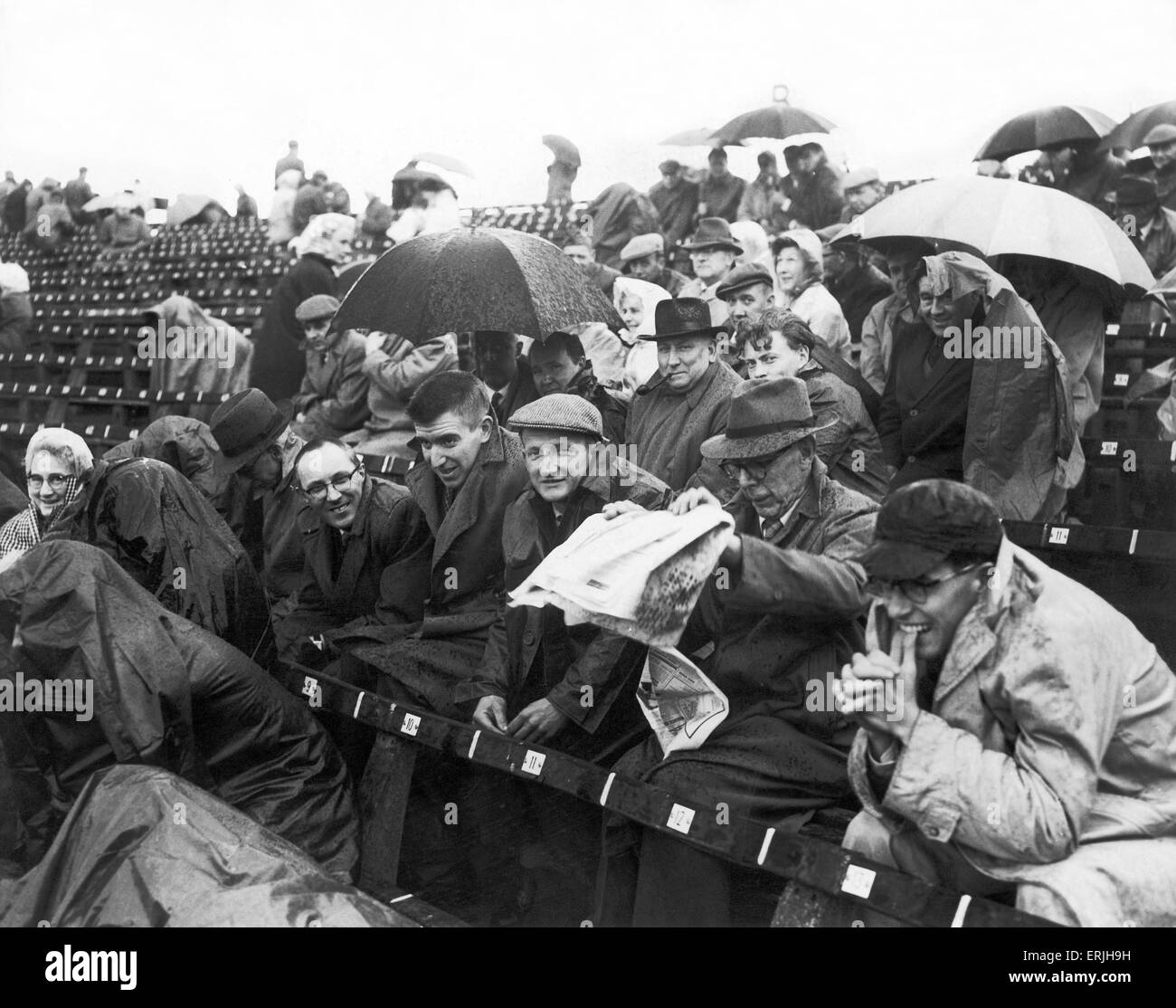 Australian cricket tour of England for the Ashes. England v Australia First Test match at Edgbaston. Spectators try to take shelter from the rain.  June 1961. Stock Photo