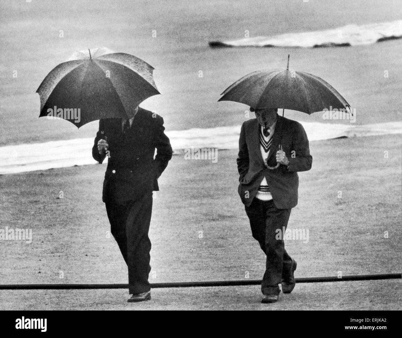 Australian cricket tour of England for the Ashes. England v Australia First Test match at Edgbaston. From underneath the umbrellas of umpires Sid Buller (left) and Frank Lee, the decision of no more play today is made. 12th June 1961. Stock Photo