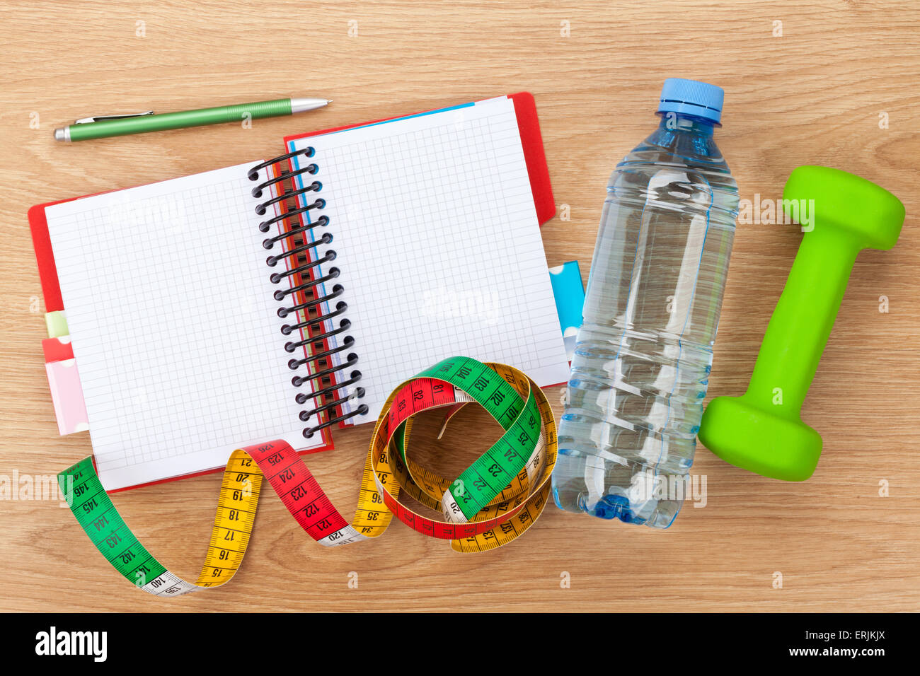 Dumbells, tape measure, water bottle and notepad for copy space