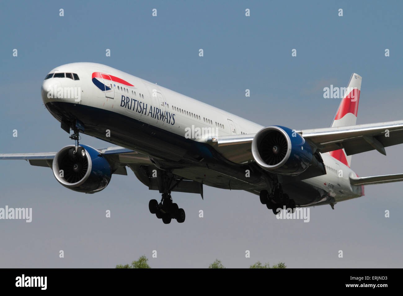 British Airways Boeing 777-300ER twin-engine long-haul commercial jet plane on approach. Close up front view emphasising size of aircraft and engines. Stock Photo