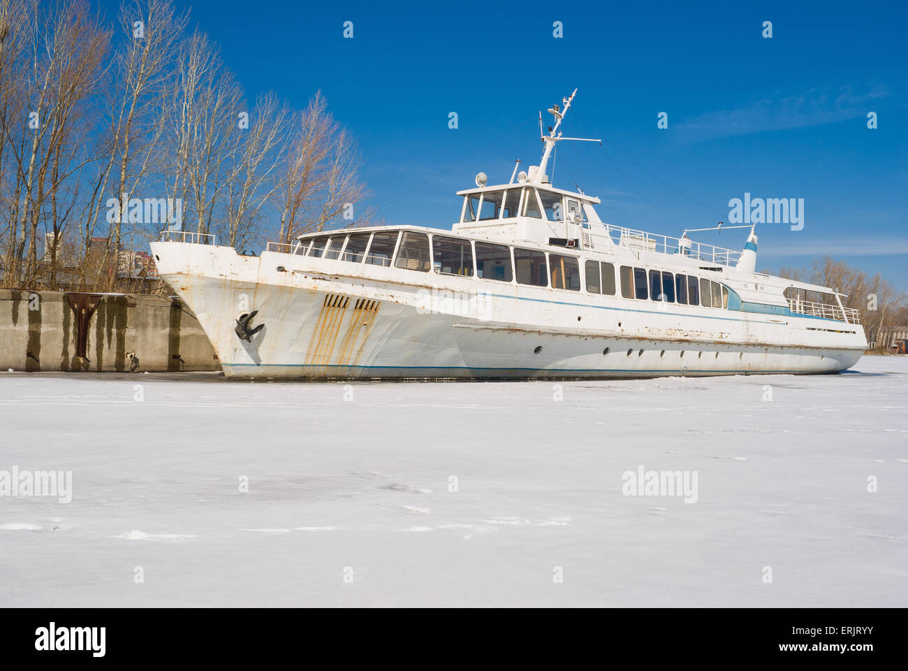 An old pleasure boat iced-bound on a winter berthing. Stock Photo