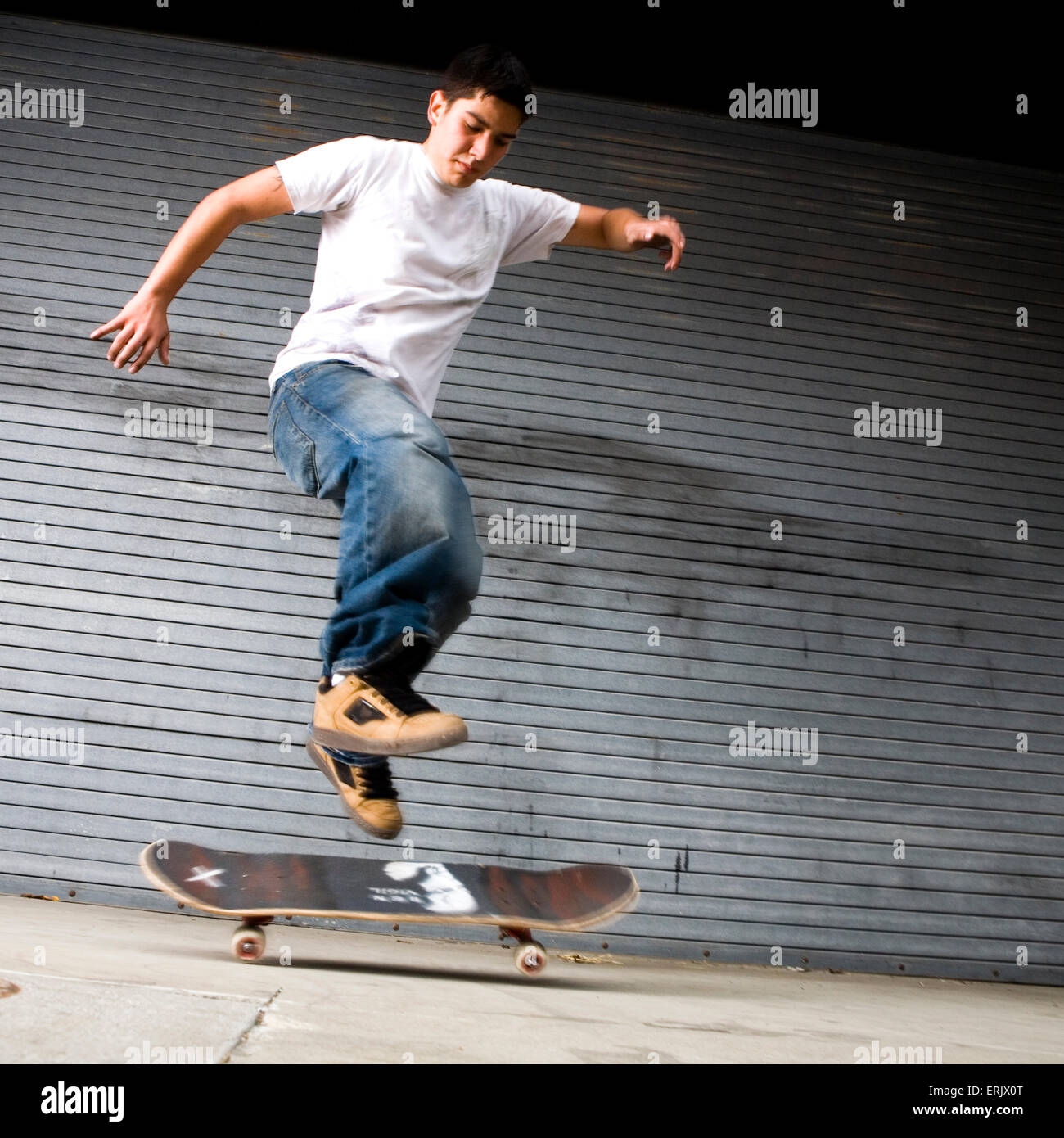 Skateboarder doing a street trick in an urban enviroment. Stock Photo