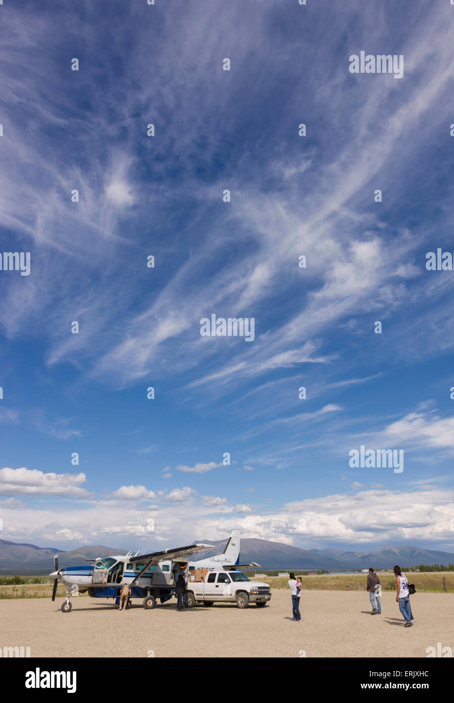 Villagers gather around a plane to load supplies, Shungak airport
