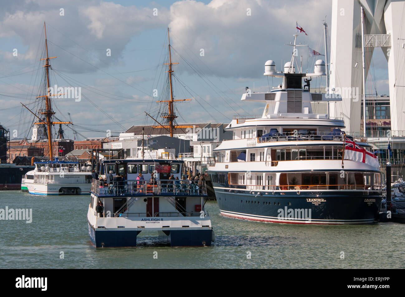 Pleasure boat passengers admire Super Yacht. Stock Photo