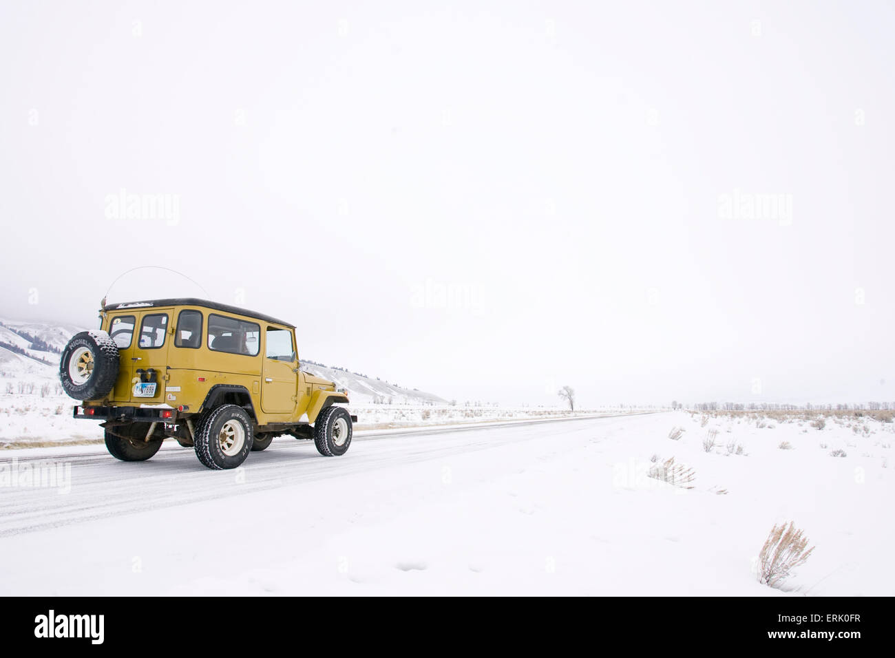 A view of a yellow landcruiser in the snow in Jackson, Wyoming. Stock Photo
