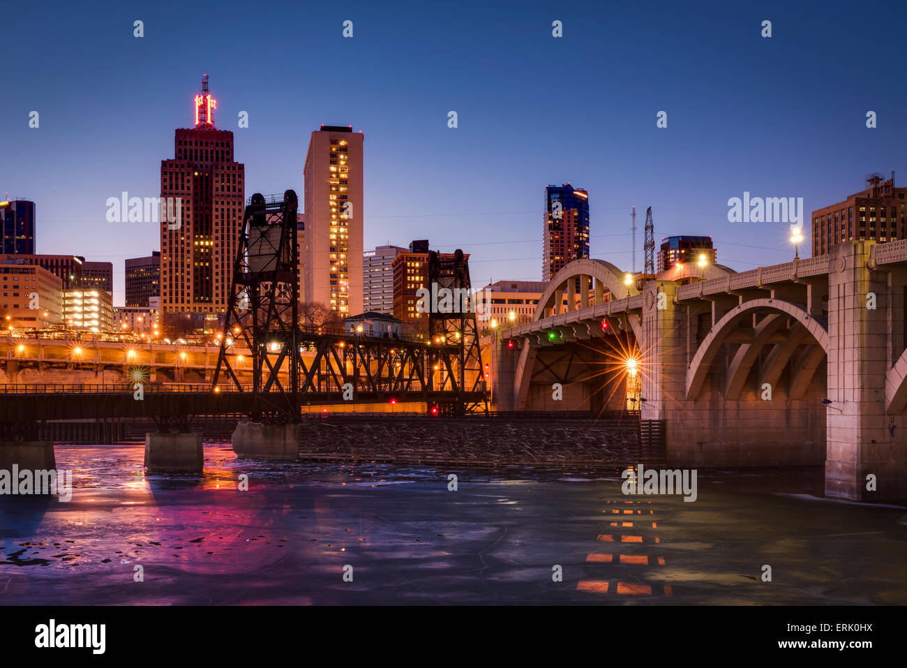 Ice covered Mississippi River and St. Paul skyline with railroad bridge and Roberts Street bridge at dusk. Stock Photo