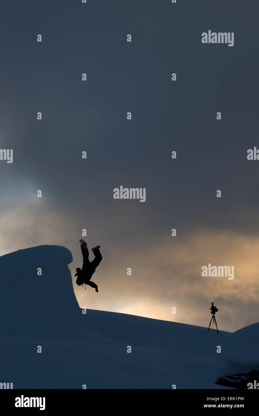 Silhouette of a man somersaulting of a snow ledge, St. Moritz, Switzerland Stock Photo